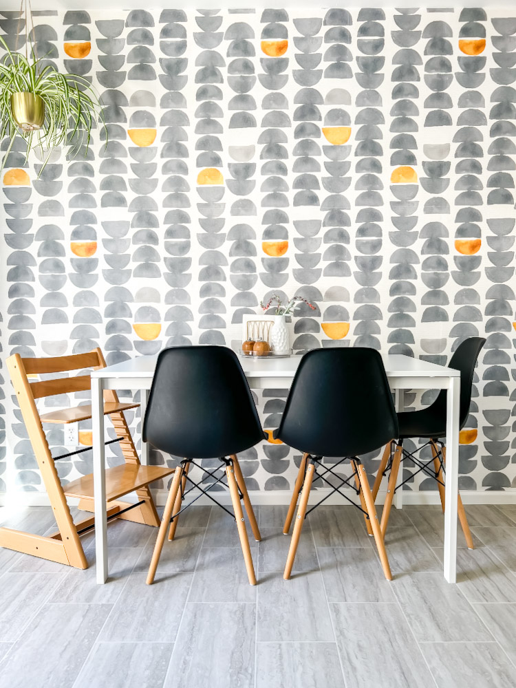 Updated breakfast nook with black chairs and wallpaper