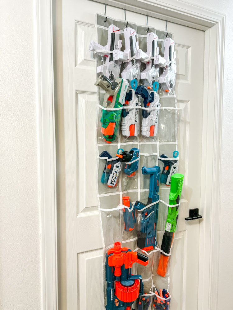Nerf blasters stored behind the door