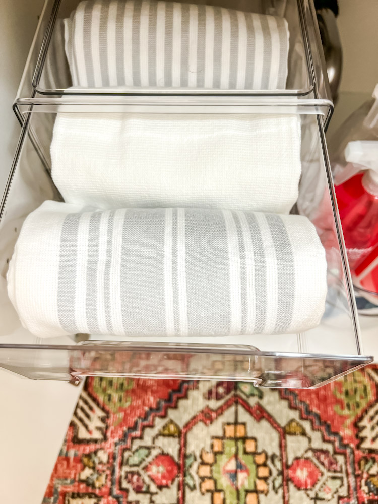 folded dish towels in under the sink bins